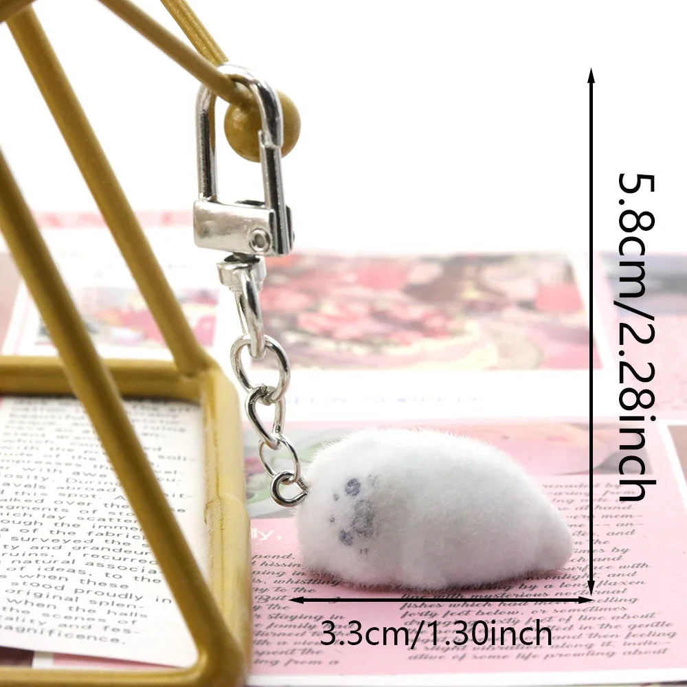 Small white stone with a silver heart charm on a pink background