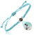 A light blue braided cord bracelet with an adjustable sliding knot and a central silver-toned bezel holding a dark oval stone. A photo projection of a couple