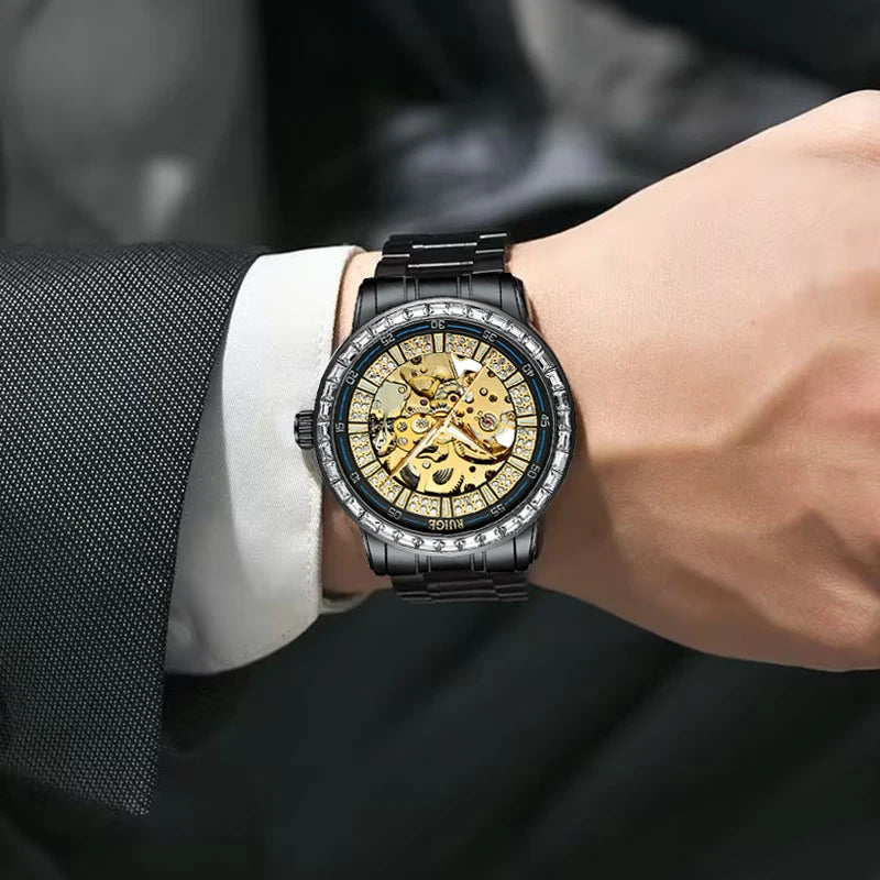 Luxury watch with black and gold design on a person's wrist, wearing a suit.