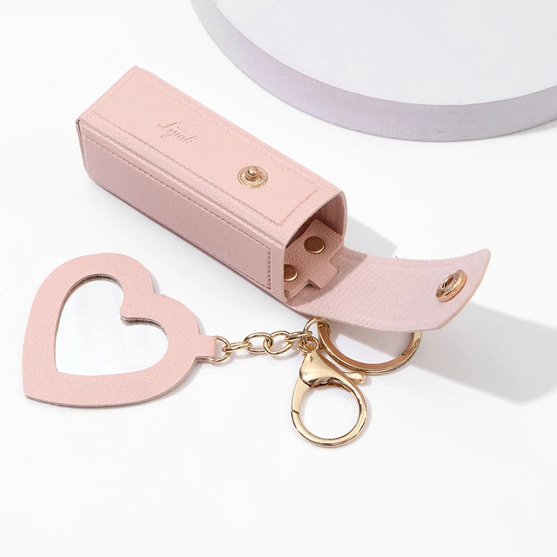 Pink heart-shaped keychain with gold accents on a white background
