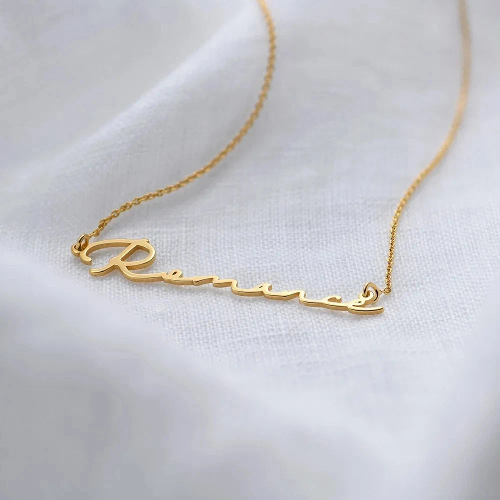 Gold necklace with 'Renée' pendant on a white background