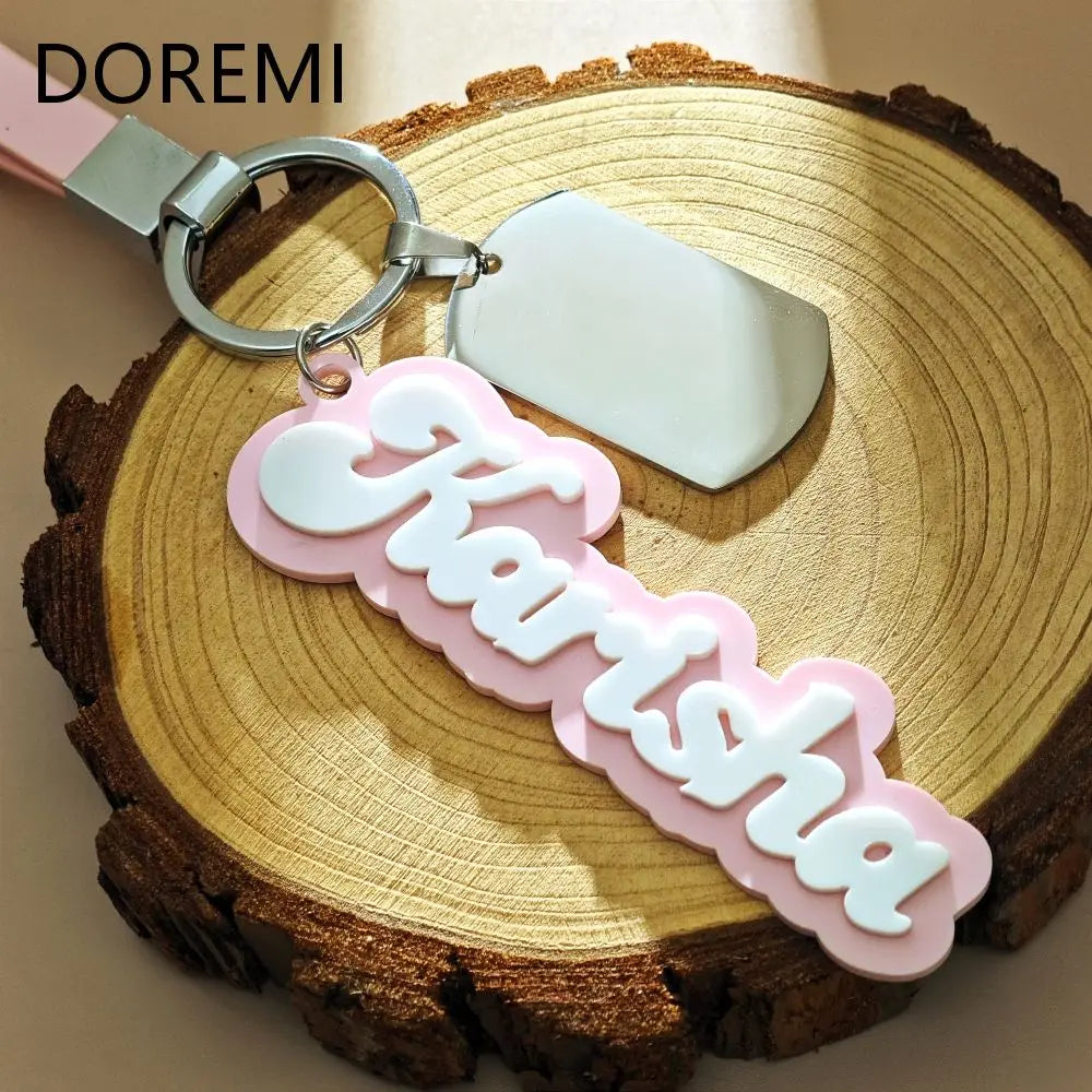 Keychain with 'FARISHA' on a wooden surface, featuring the brand 'DOREMI'.