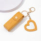 Yellow keychain with heart design and matching pouch on a white background
