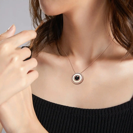 Necklace with a pendant worn by a person against a neutral background