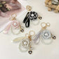 Set of decorative keychains with pearls and ribbons on a light background