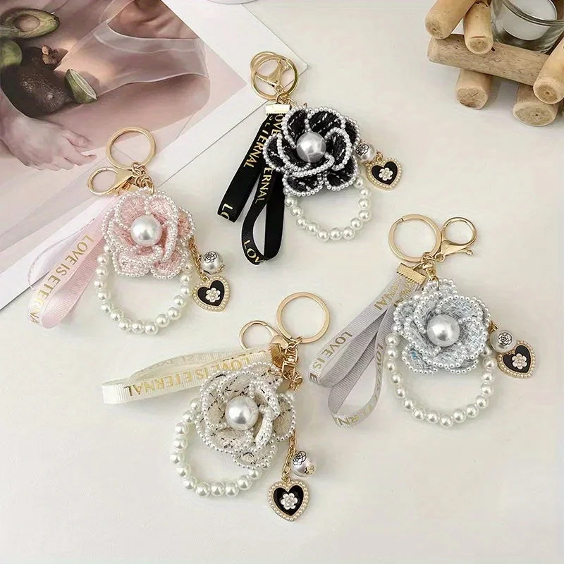Set of decorative keychains with pearls and ribbons on a light background