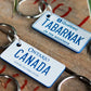 Two keychains with imitation license plate designs on a wooden surface.