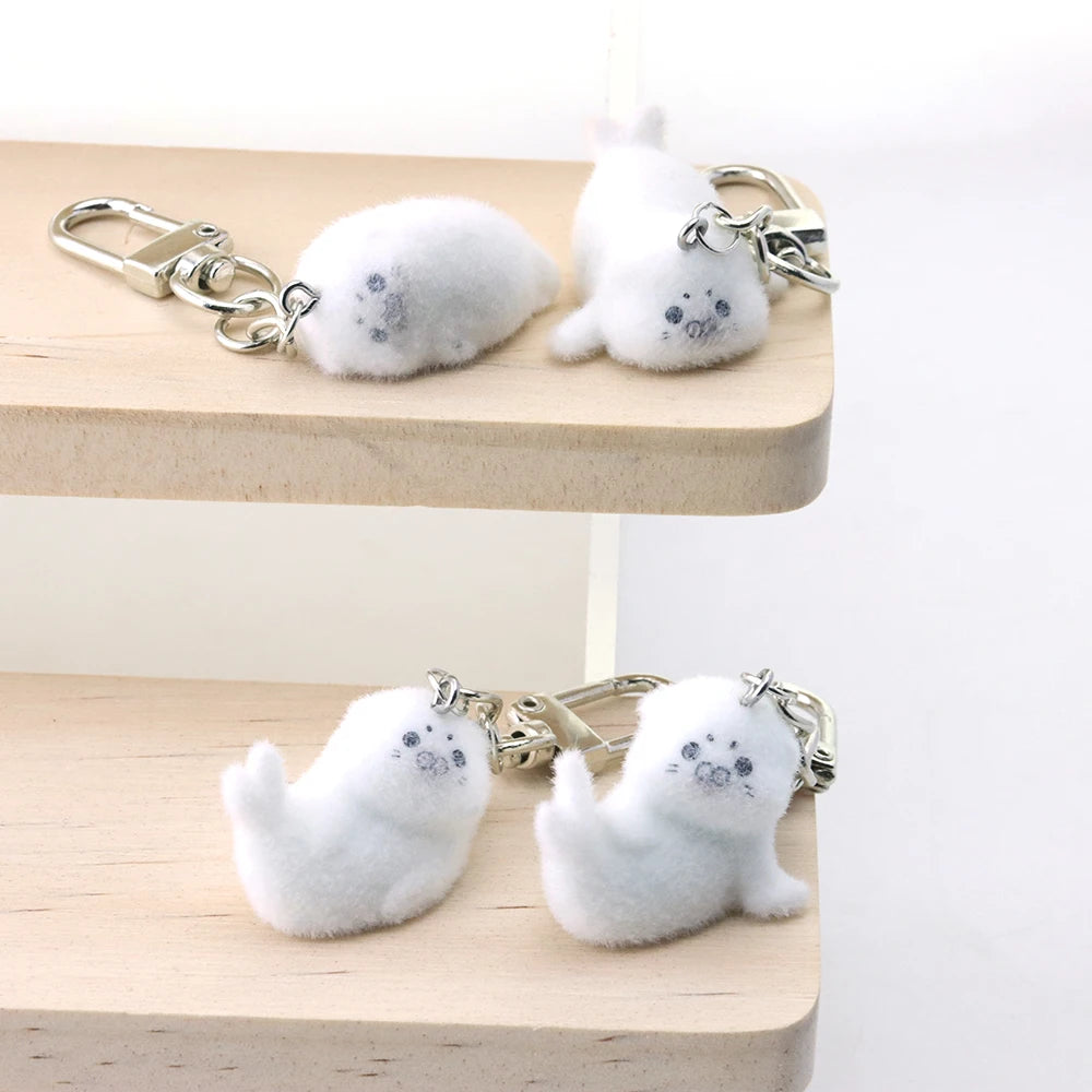 White seal-shaped keychains on a wooden stand with a white background