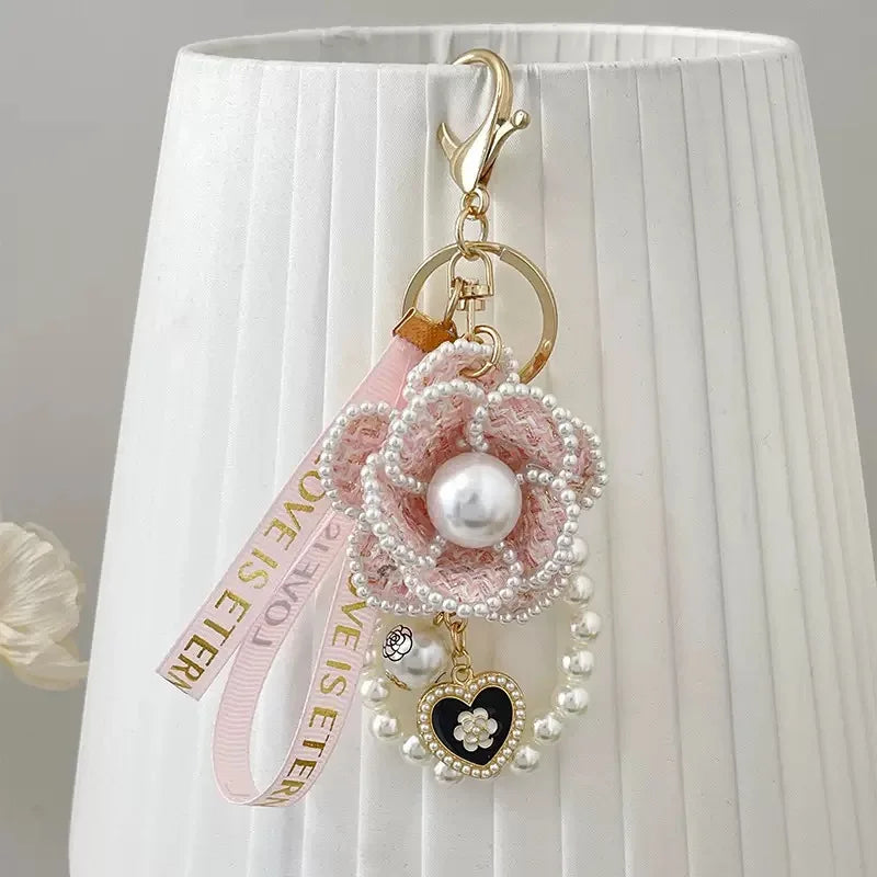Decorative keychain with pearls and heart charm on a white lampshade background