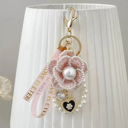 Decorative keychain with pearls and heart charm on a white lampshade background