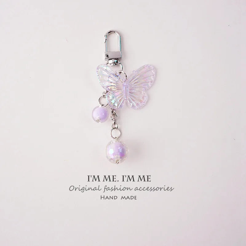 Butterfly-shaped keychain with beads on a light pink background, featuring 'I“ME I“ME' branding.