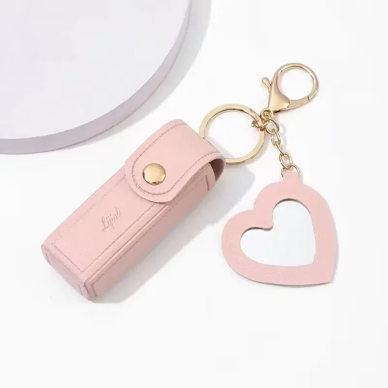 Pink keychain case with heart-shaped keychain on a white background