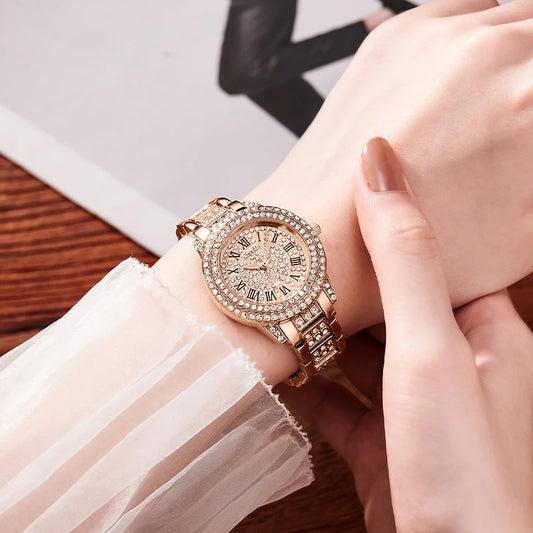 Rose gold watch with diamond accents on a wrist, blurred background